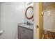 Bathroom with a granite vanity, round mirror, and neutral walls at 1924 Strebor St, Durham, NC 27705