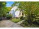 View of a home with a light blue exterior, red shutters, and mature landscaping at 1924 Strebor St, Durham, NC 27705