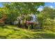 Charming two-story home with red shutters, lovely landscaping, and a lush lawn surrounded by mature trees at 1924 Strebor St, Durham, NC 27705