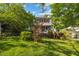 Charming two-story home with red shutters, lovely landscaping, and a lush lawn surrounded by mature trees at 1924 Strebor St, Durham, NC 27705
