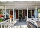 Cozy front porch with white railings, planters, and seating area at 1924 Strebor St, Durham, NC 27705