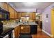 Well-lit kitchen with granite countertops, tiled backsplash, and wood cabinets, adjacent to a cozy living space at 1924 Strebor St, Durham, NC 27705