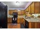 Kitchen featuring wooden cabinets, granite countertops, and black appliances at 1924 Strebor St, Durham, NC 27705
