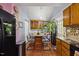 Spacious kitchen area with breakfast bar, wooden cabinets, a black refrigerator and a view of greenery at 1924 Strebor St, Durham, NC 27705