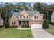 Charming two-story home with brick and tan siding, featuring a manicured lawn and a two-car garage at 200 Heather Brook Cir, Spring Lake, NC 28390