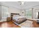 Serene main bedroom featuring tray ceilings, hardwood floors, and ample natural light, providing a peaceful retreat at 200 Heather Brook Cir, Spring Lake, NC 28390