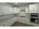 Bright kitchen with white cabinets, gray countertops, and stainless steel appliances at 214 Alden Way, Angier, NC 27501