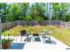 Backyard with a seating area, surrounded by a wooden fence and green trees at 224 Brisk Dr, Zebulon, NC 27597