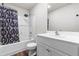 Well-lit bathroom featuring a shower with patterned curtain and a vanity with white cabinets at 224 Brisk Dr, Zebulon, NC 27597