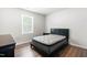 Cozy bedroom featuring a comfortable bed, hardwood floors, a window, and side tables at 224 Brisk Dr, Zebulon, NC 27597