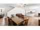 Open-concept dining room featuring hardwood floors, a ceiling fan, and an adjacent kitchen and living area at 224 Brisk Dr, Zebulon, NC 27597