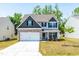 Charming two-story home with a manicured lawn, stone accents, and a welcoming front porch at 224 Brisk Dr, Zebulon, NC 27597