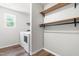 Clean laundry room with modern washer, dryer, and convenient shelving at 224 Brisk Dr, Zebulon, NC 27597