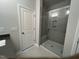 Modern bathroom featuring a glass-enclosed shower with a built-in seat and sleek gray tiling at 2297 Bay Minette Sta # 536, Apex, NC 27502