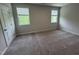 Spacious bedroom with neutral carpet, two windows for natural light, and a clean, modern aesthetic at 2297 Bay Minette Sta # 536, Apex, NC 27502