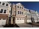 New townhome with attached garage and a mixed material facade of siding and brick under a clear blue sky at 2297 Bay Minette Sta # 536, Apex, NC 27502