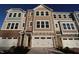 New townhome with attached garage and a mixed material facade of siding and stone under a clear blue sky at 2297 Bay Minette Sta # 536, Apex, NC 27502