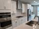 Modern kitchen boasts stainless steel appliances, white cabinetry, and a stylish herringbone backsplash at 2297 Bay Minette Sta # 536, Apex, NC 27502