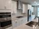 Modern kitchen boasts stainless steel appliances, white cabinetry, and a stylish herringbone backsplash at 2297 Bay Minette Sta # 536, Apex, NC 27502