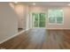 Living room showcasing wood floors, sliding glass door to balcony, and stairs to the upper level at 2297 Bay Minette Sta # 536, Apex, NC 27502