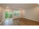 Bright living room with wood floors and sliding glass doors leading to a deck overlooking a wooded area at 2297 Bay Minette Sta # 536, Apex, NC 27502