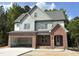 Elegant two-story home with a brick-accented front and two-car garage, set against a backdrop of trees at 2408 Eagle Shot Ct # 4, Fuquay Varina, NC 27526
