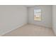 Cozy bedroom with neutral carpet, white walls, and a window at 2522 Dalmahoy Ln, Fuquay Varina, NC 27526