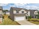 Side view of a two-story home featuring neutral siding, a two-car garage, and a well manicured lawn at 2522 Dalmahoy Ln, Fuquay Varina, NC 27526