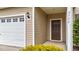 Exterior view of front door and garage with white door, brown door, and manicured shrubbery at 2522 Dalmahoy Ln, Fuquay Varina, NC 27526