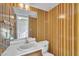 Retro bathroom featuring unique striped wallpaper and a classic vanity at 2608 Foxgate Dr, Raleigh, NC 27610