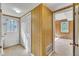Hallway features patterned wallpaper, a door to outside, and a view into the wood-paneled room at 2608 Foxgate Dr, Raleigh, NC 27610
