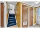 Hallway features staircase with blue carpet and patterned wallpaper at 2608 Foxgate Dr, Raleigh, NC 27610