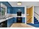 Bright kitchen features blue cabinetry, white countertops, and black appliances at 2608 Foxgate Dr, Raleigh, NC 27610