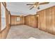 Spacious living room with carpet, wood-paneled walls, and ceiling fan lighting at 2608 Foxgate Dr, Raleigh, NC 27610