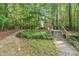 Tranquil walking path with wooden stairs leading into the lush, green wooded area at 2608 Foxgate Dr, Raleigh, NC 27610
