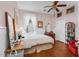 Cozy bedroom features hardwood floors, a ceiling fan, and warm pink walls at 302 Villa St, Rocky Mount, NC 27804
