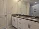 Bathroom with double sinks, white cabinets, gray countertop and tiled shower at 3026 Freewinds Way # 50, Cary, NC 27519