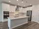 Kitchen features white cabinets, stainless appliances, large island with sink, and modern pendant lighting at 3026 Freewinds Way # 50, Cary, NC 27519