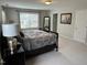 Cozy bedroom with a neutral color scheme, large window, and a dark wood bed frame at 3032 Kilarney Ridge Loop, Cary, NC 27511