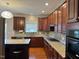 Beautiful kitchen with granite countertops, rich wooden cabinets, stainless steel appliances, and hardwood floors at 3032 Kilarney Ridge Loop, Cary, NC 27511