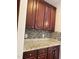 Close up of kitchen with granite countertops, mosaic tile backsplash, and dark wood cabinets at 3032 Kilarney Ridge Loop, Cary, NC 27511