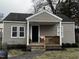 Charming single-story home with gray siding and inviting front porch seating at 311 Oakley St, Graham, NC 27253