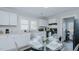 Bright eat-in kitchen with white cabinets, modern appliances, and a breakfast nook with a glass table at 311 Oakley St, Graham, NC 27253