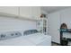 Well-organized laundry room featuring a side-by-side washer and dryer, overhead cabinets, and shelves at 311 Oakley St, Graham, NC 27253