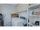 Well-organized laundry room featuring a side-by-side washer and dryer, overhead cabinets, and shelving for storage at 311 Oakley St, Graham, NC 27253