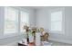 Bright living room with three windows offering ample natural light, a patterned chair and a bouquet of flowers at 311 Oakley St, Graham, NC 27253