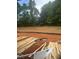 Image of lot under construction with lumber and soil, framed by mature trees, hinting at a private and scenic backyard at 314 Shiloh Way, Mebane, NC 27302
