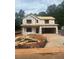 Two-story home under construction with visible framing and sheathing, driveway, and a lush green backdrop at 314 Shiloh Way, Mebane, NC 27302