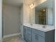Bathroom with dual sinks, a large mirror, gray cabinets, and a door to the commode at 33 Brooklynn Trail # 181, Angier, NC 27501