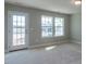 Carpeted bedroom with a door to the outside and plenty of natural light coming in through the large windows at 33 Brooklynn Trail # 181, Angier, NC 27501
